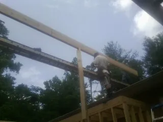 Carpenter setting a ridge beam over a new addition frame — Ice Dam Removal by Roofing Brothers in Bates City