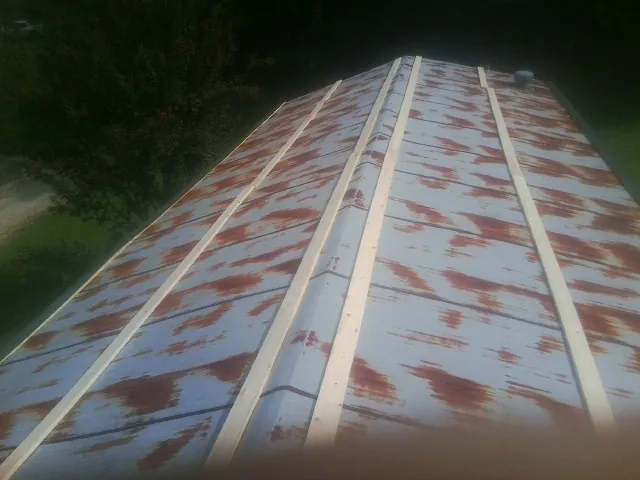Rusted metal roof panels with new wood purlins before replacement — Storm Damage Roof Repair in Bates City by Roofing Brothers